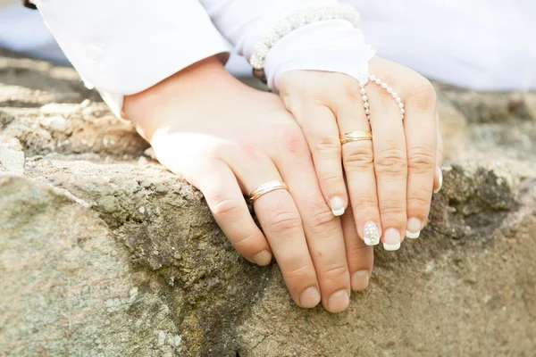 Обручальные кольца на пальцах жениха и невесты . — стоковое фото