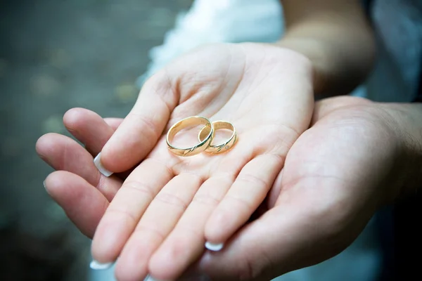 Wedding rings with the couple — Stock Photo, Image