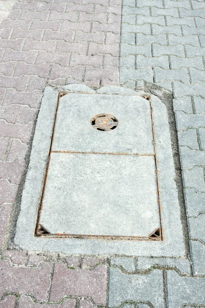 Alcantarillado en la acera de la ciudad — Foto de Stock