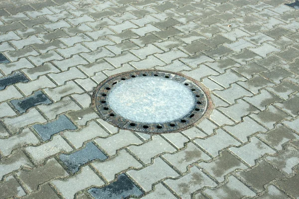 Sewer drain on the sidewalk in the city — Stock Photo, Image