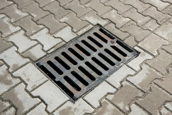 Sewer drain on the sidewalk in the city Stock Picture