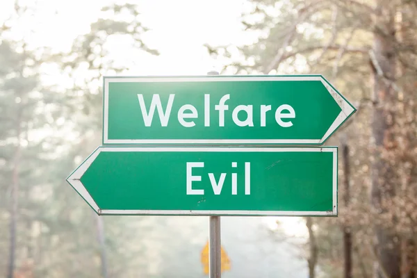 Signpost on two sides - Welfare or Evil — Stock Photo, Image