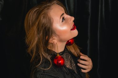 Güzel sarışın uzaklara bakıyor. Noel ağacı süslemelerinden bir kıyafet. Yeni yıl konsepti. Metnin için yer