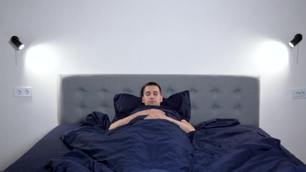 남자는 일어나서 침대에서 나온다 잠에서 일어나는 정신으로 — 비디오