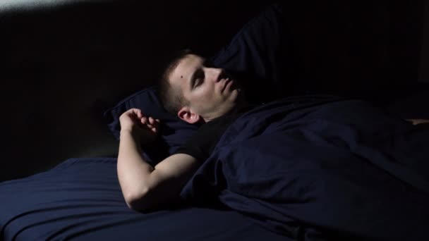 Sono perturbado. Tenho pesadelos. O jovem atira e se vira para a cama. Coberto com um cobertor sobre a cabeça. — Vídeo de Stock