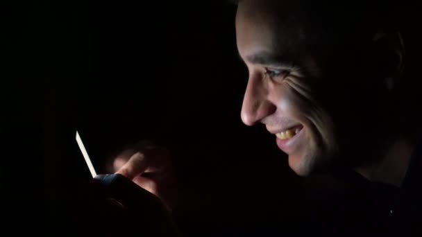 Il ragazzo sta messaggiando con la sua amata al telefono. Sorridente guardando il telefono. — Video Stock