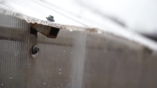 Draußen tropft dicker Regen an die Wand des Gewächshauses. ein Wasserstrahl ergießt sich aus nächster Nähe. Kunststoffwand in Tropfen — Stockvideo