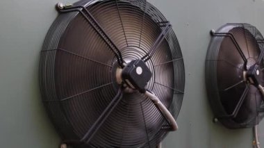industrial air conditioner extractor fan hanging on the wall outside the building. refrigeration blower running and spinning close up