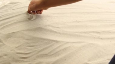 hand draws the inscription Greece on the sand. Sunny coast of the sea and ocean. Symbol of rest and vacations at the resort