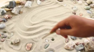 hand draws the inscription Happy on the sand. Sunny coast of the sea and ocean. Symbol of rest and vacations at the resort