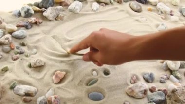 hand draws the inscription Relax on the sand. Sunny coast of the sea and ocean. Symbol of rest and vacations at the resort
