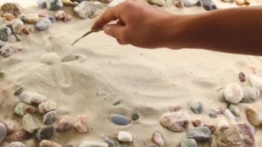 hand draws the inscription Happiness on the sand. Sunny coast of the sea and ocean. Symbol of rest and vacations at the resort