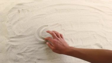 hand draws the inscription Sea on the sand. Sunny coast of the sea and ocean. Symbol of rest and vacations at the resort
