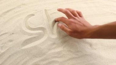 El, kuma Shell yazısını çizer. Deniz ve okyanusun güneşli kıyıları. Tatil ve dinlenme yeri sembolü