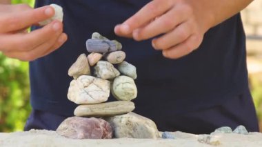İnsanoğlu deniz taşlarından bir piramit inşa eder. Yumuşak çakıl yığını. Zen taşları yakın plan. Huzur ve dinlenme konsepti.