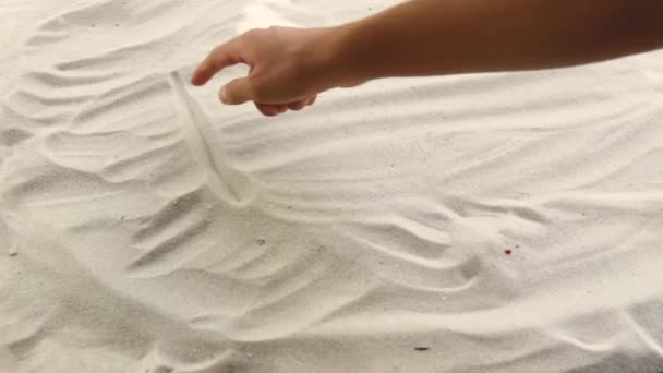 Hand draws the inscription Dubai on the sand. Sunny coast of the sea and ocean. Symbol of rest and vacations at the resort — Stock video