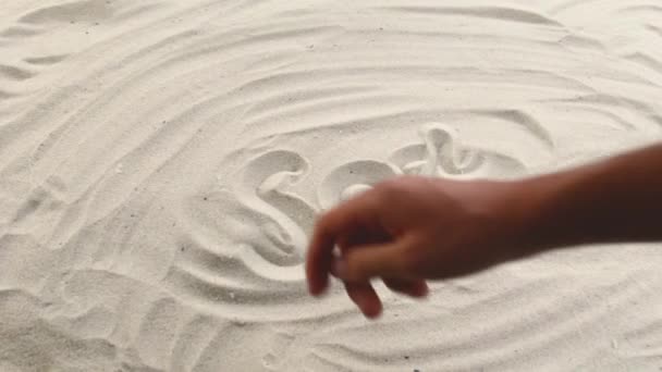 Mano dibuja la inscripción Mar de Coral en la arena. Costa soleada del mar y el océano. Símbolo de descanso y vacaciones en el resort — Vídeos de Stock