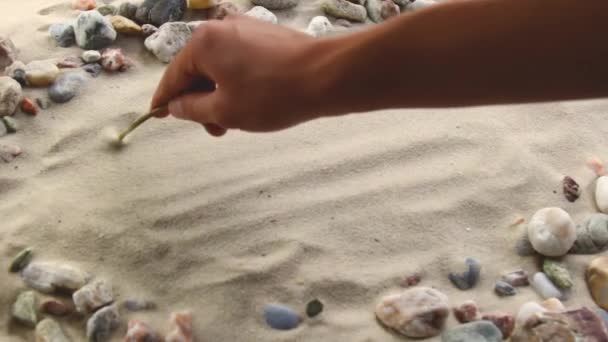 Mano dibuja la inscripción Pulpo en la arena. Costa soleada del mar y el océano. Símbolo de descanso y vacaciones en el resort — Vídeos de Stock