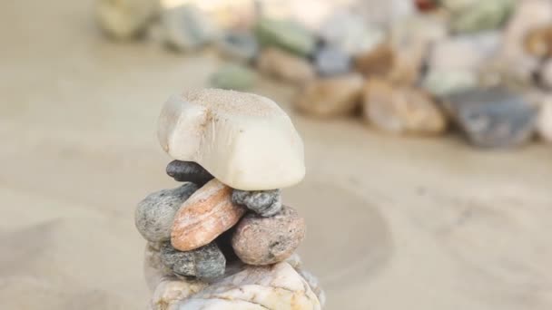 Sand pours on a pyramid of sea stones. heap of smooth pebbles. zen stones close-up. the concept of peace of mind and relaxation in the resort — Vídeo de Stock