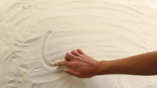 Χέρι σχεδιάζει την επιγραφή Ωκεανός στην άμμο. Ηλιόλουστη ακτή της θάλασσας και του ωκεανού. Σύμβολο ξεκούρασης και διακοπών στο θέρετρο — Αρχείο Βίντεο