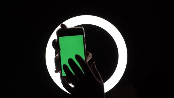 Vrouwelijke handen tonen de telefoon close-up op een zwarte achtergrond. groen scherm mockup voor reclame insert. Beweegt vingers over het scherm, tikken, vegen, typen — Stockvideo