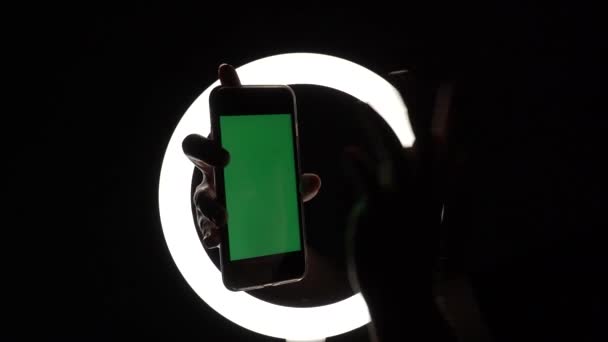 女性的手显示手机在黑色背景下的特写。用于广告插入的绿色屏幕模型。将手指移动到屏幕上，点击，滑动，键入 — 图库视频影像