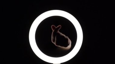 Bir sürü jest. Kadın eli yakın plan parmak figürleri yapar. Parmak oyunu, kalp şeklinde avuçlar. Eller aşkın sembolünü gösterir