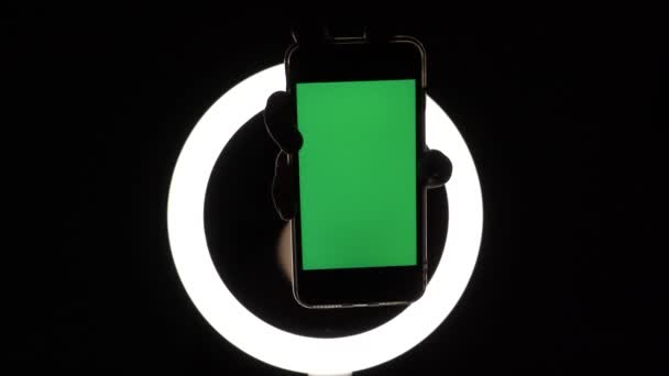 Manos femeninas muestran el primer plano del teléfono sobre un fondo negro. maqueta de pantalla verde para insertar anuncios — Vídeo de stock