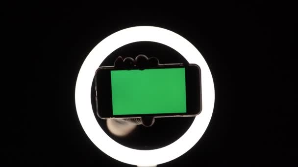 Manos femeninas muestran el primer plano del teléfono sobre un fondo negro. maqueta de pantalla verde para insertar anuncios — Vídeo de stock