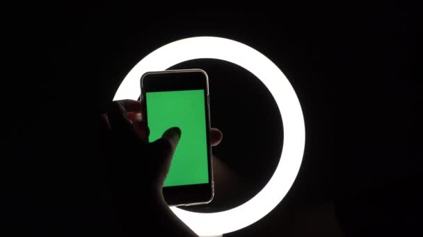 Female hands show the phone close-up on a black background. green screen mockup for advertising insert. Moves fingers across the screen, taps, swipes, types — ストック動画