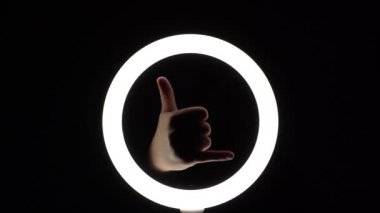 Jest paketi. Kadın eli yakın plan parmak figürleri yapar. Parmak oyunu. Shaka işareti yap ya da bana Jest de. serçe ve baş parmak.