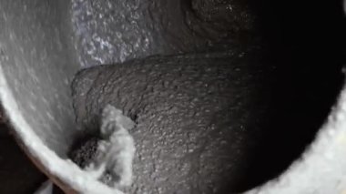 Beton karıştırıcı binanın karışımını karıştırıyor. Dönüşümlü inşaat aleti yakın çekim. Gri yapım yapıştırıcılı inşaat işi