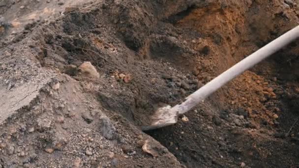 Seorang pekerja menggali tanah dengan sekop close-up 4K. Trolley penuh bumi. Buatan tangan dengan alat bantu di rumah — Stok Video