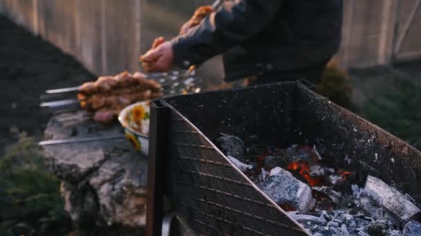 Человек готовит барбекю на шашлыках на гриле на улице. Барбекю на открытом воздухе. Пикник на природе. Кусочки мяса на шампуре — стоковое видео