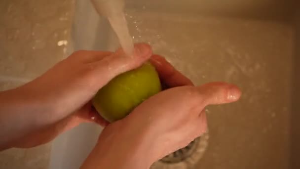 Le mani di una governante lavano una mela nel lavandino di cucina primo piano vista dall'alto 4K. Una corretta alimentazione, assistenza sanitaria — Video Stock
