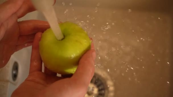 Les mains d'une femme de ménage lave une pomme dans l'évier de cuisine vue rapprochée 4K. Nutrition adéquate, soins de santé — Video