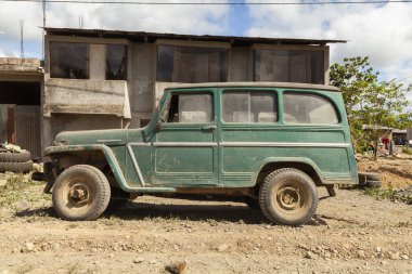 Pilcopata, Peru - 12 Nisan 2014: Küçük Pilcopata kasabasının sokaklarından birine park edilmiş yeşil renkli eski bir off-road aracı