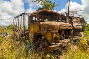 Pilcopata, Peru - 12 Nisan 2014: Eski, paslı ve terk edilmiş, yabani otlar tarafından yutulmuş sarı bir kamyon, Pilcopata 'nın çevresinde dinleniyor.