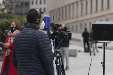 Madrid, İspanya - 28 Ekim 2020: Kulaklıklı bir kamera operatörü, milletvekilleri meclisi önünde kayıt için bekliyor