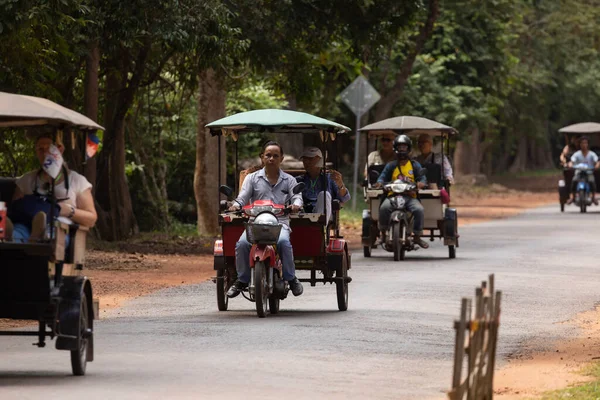 Angkor, Kamboçya - 24 Kasım 2019: Angkor Arkeoloji Parkı, Siem Reap Parkı 'ndaki Angkor Wat yolu boyunca turistleri götüren birçok tuk tuk, transit