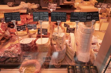 Zaragoza, İspanya - 12 Ağustos 2021: Tedavi edilmiş peynir ve diğer ürünler, merkezi Zaragoza veya Lanuza pazarındaki bir şarküterinin tezgahında sergilenmektedir.