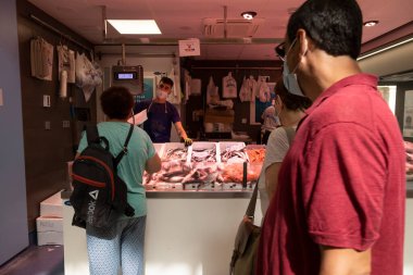 Zaragoza, İspanya - 12 Ağustos 2021: Birkaç kişi Mercado şehir merkezindeki veya Lanuza pazarındaki balık dükkanlarından birinden alışveriş sırasını bekliyor