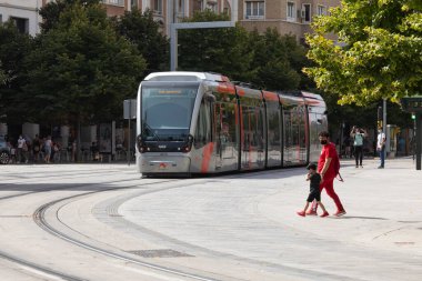 Zaragoza, İspanya - 12 Ağustos 2021: Zaragoza 'daki Paseo Independencia boyunca bir tramvay hareket ederken, bir baba oğluyla rayları geçmeye çalışır.