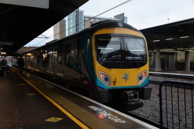 Manchester, İngiltere - 08 Aralık 2021: Manchester Havaalanı tren istasyonundaki platformlardan birine park edilmiş tren Manchester Piccadilly, İngiltere 'ye gidiyor.