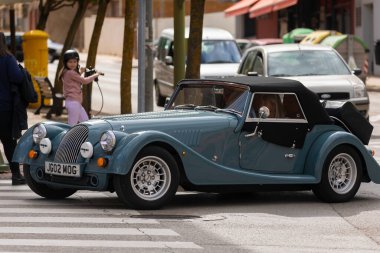 Soria, İspanya - 14 Nisan 2022: Klasik klasik görünümlü, restore edilmiş ve modernize edilmiş eski bir araba, Soria 'nın merkezinde Juan Baltanas caddesi boyunca sürüyor.