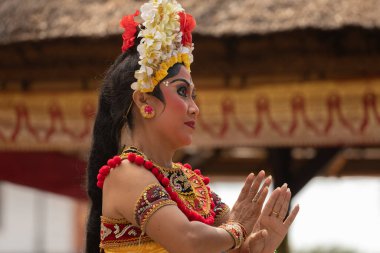 Bali, Endonezya - 28 Ağustos 2019: Geleneksel kostüm giymiş bir kadın, Bali halkı arasındaki dini ve sanatsal ifadenin bir parçası olan antik Bali dans geleneğini icra ediyor