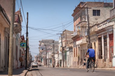 Cienfuegos, Küba - Nisan. 04, 2010: Bir adam şehir merkezi ve tarihi ilçenin caddelerinde ve mahallelerinde bisiklet sürüyor