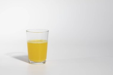 Glass of orange juice, or medicine with orange color, isolated on white background, real photo studio, no 3D