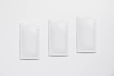 Mockup of three isolated envelopes of medicine, for powder, with blank label for packaging design, on white background, real photo studio, no 3D