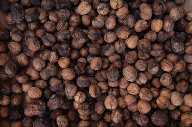 Ceviz arkaplan dokusu, kabuksuz ve işlenmemiş sağlıklı besinler, ılık sonbahar tonlarında.